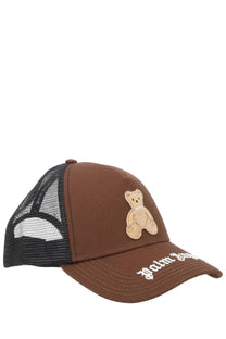Brown palm angels men’s trucker hat with beige embroidered teddy bear patch and white palmer lettering on brim