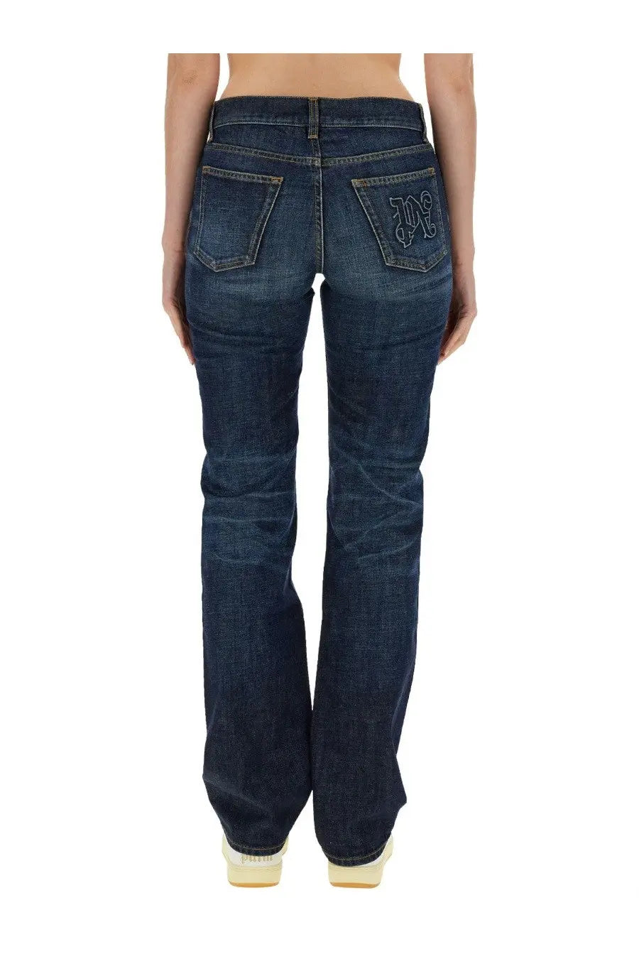 Back view of palm angels women’s dark blue denim straight leg jeans with embroidered logo on the pocket