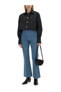 Black leather crossbody bag with minimalist design and gold-tone hardware paired with patou women’s flare fit jeans blue