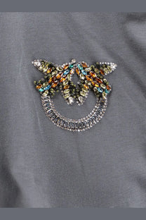 A sparkling multicolored rhinestone brooch shaped like a smiling face with wings on a pinko womens grey cotton shirt