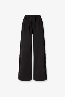 Black wide-leg denim trousers by Pinko featuring sheer lace trim along the outer seams for women