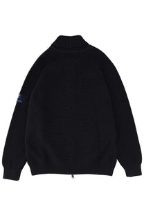 Premiata men’s wool jacket blue shown with black ribbed knit turtleneck sweater with subtle blue logo patch on left sleeve