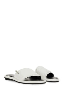 Premiata women’s white canvas slide sandal with black rubber sole and brand tag on the strap