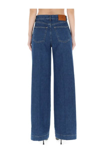 Dark blue wide-leg denim trousers with brown leather pt torino brand patch at waistband women’s jeans poppy blue