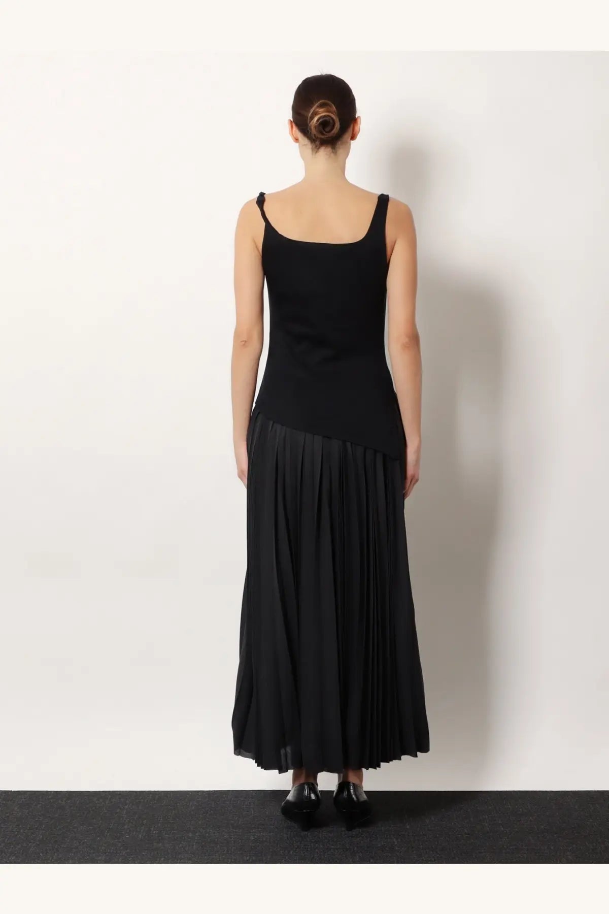 Black sleeveless knit top with square neckline and high waist paired with pleated skirt in cotton and modal blend