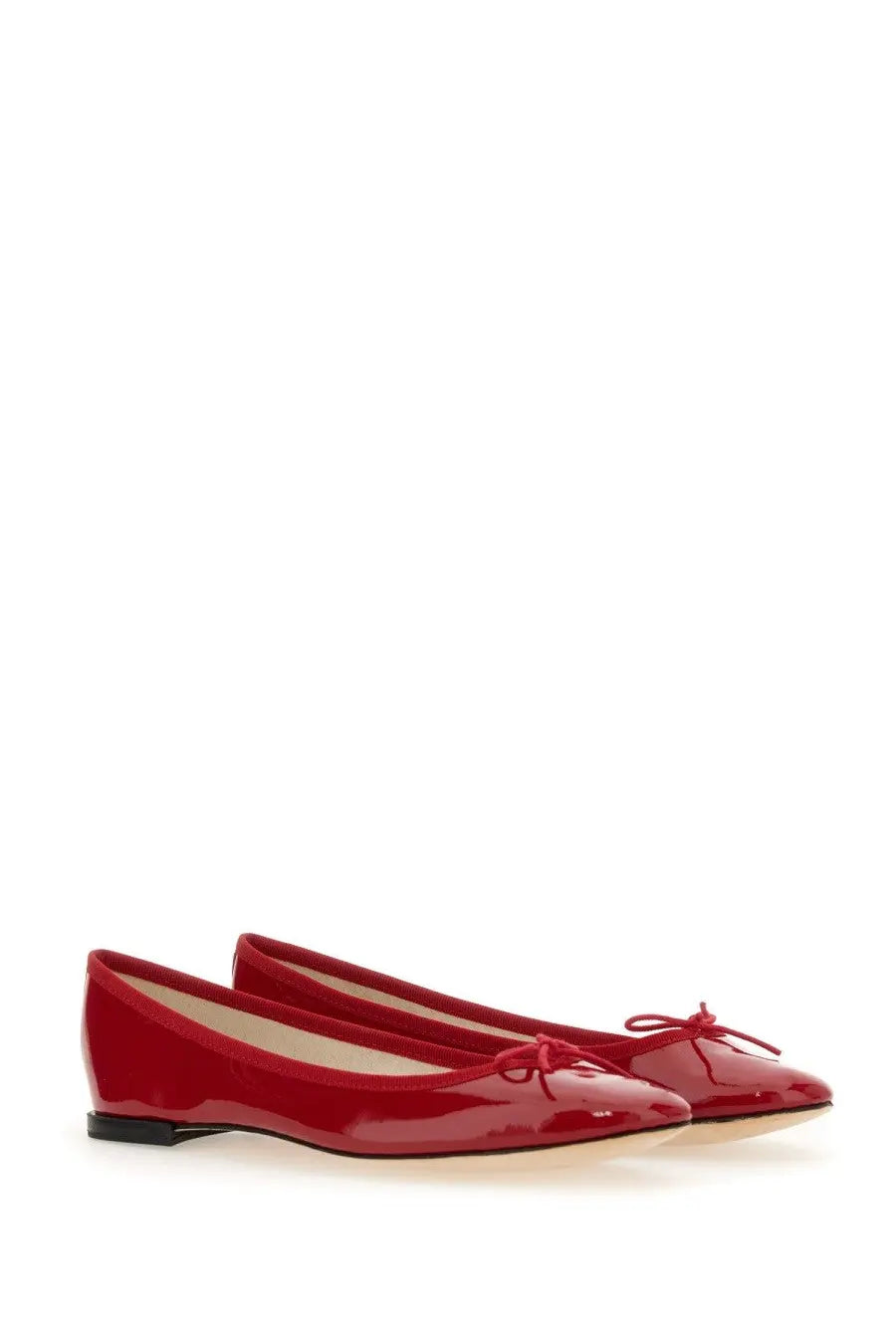Red patent leather ballet flats with a small bow at the toe from repetto women’s ballerina cendrillon red collection