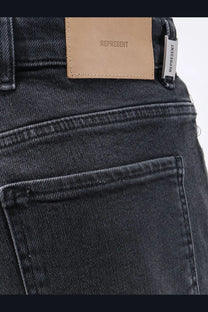 Dark-wash denim represent men’s boot cut jeans black showing tan leather brand patch and silver embroidered tag on back