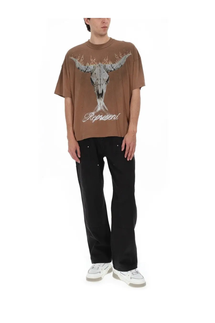 Brown oversized t-shirt with distressed skull flaming horns and ropeweni cursive print paired with represent men’s pantalon carpenter black