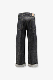 Dark-wash wide-leg denim jeans with rolled cuffs contrasting stitching and beige leather brand tag at waistband