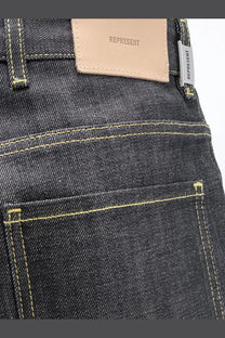 Dark-wash denim jeans with contrasting yellow stitching and beige leather patch for represent men’s selvedge denim shirt black