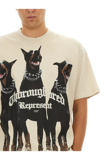 Cream-colored crewneck t-shirt featuring three black doberman pinschers with studded collars and white gothic text thoroughbred represent
