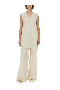 Cream-colored sleeveless v-neck top with a flowing relaxed fit paired with rick owens white wide leg pants