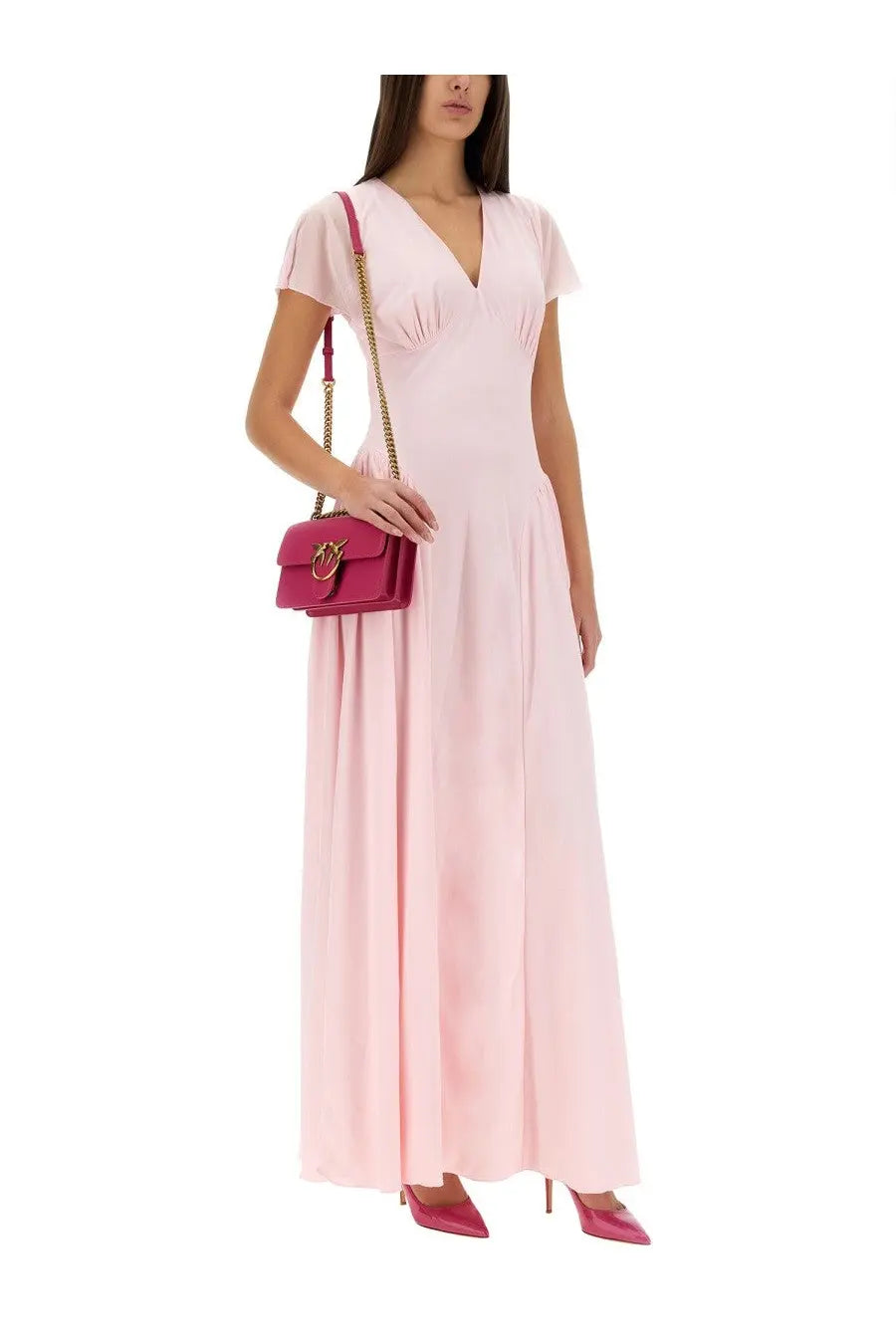 Fuchsia leather crossbody bag with gold chain strap and heart logo paired with rotate birger christensen blue long dress
