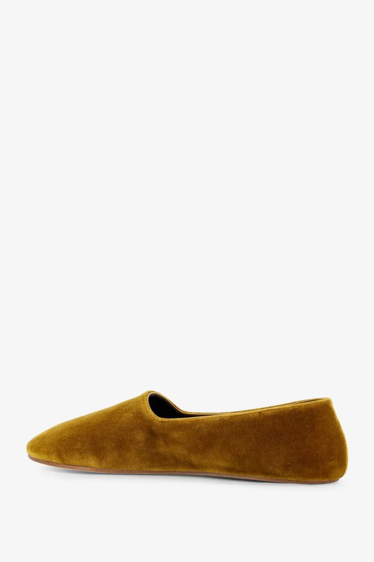 A mustard-yellow suede slip-on flat shoe with a sleek minimalist design called The Row women’s Ponti velvet loafers yellow