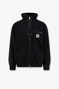 Sacai men’s black cotton sweatshirt with Carhartt hooded zip-up jacket featuring a white logo patch and silver zippers