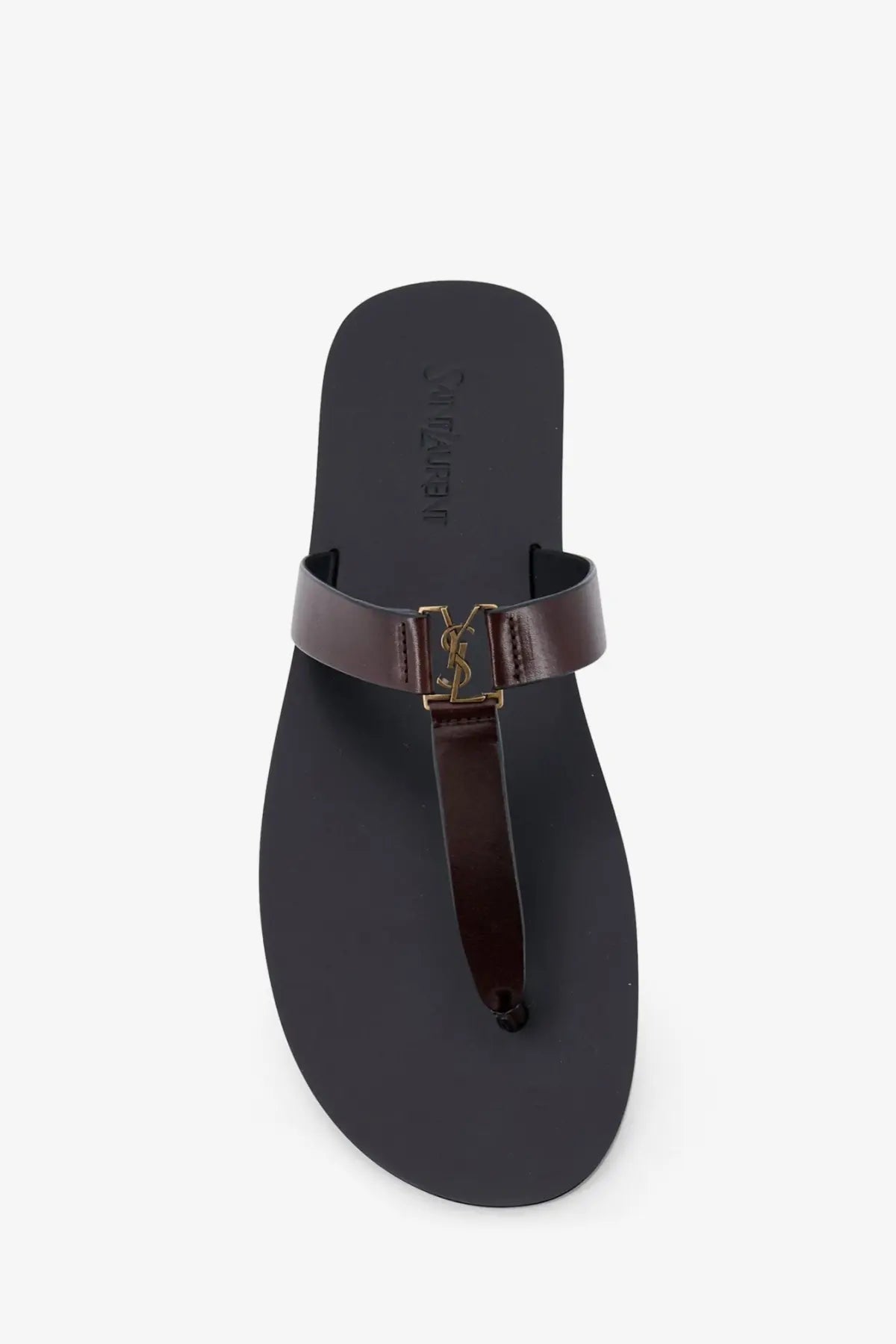 Dark brown leather Saint Laurent men’s Babylone thong sandal with gold-tone YSL logo buckle visible from the front