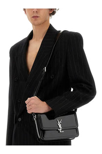 Black glossy leather crossbody bag with silver ysl logo clasp paired with saint Laurent men’s oversize black jacket