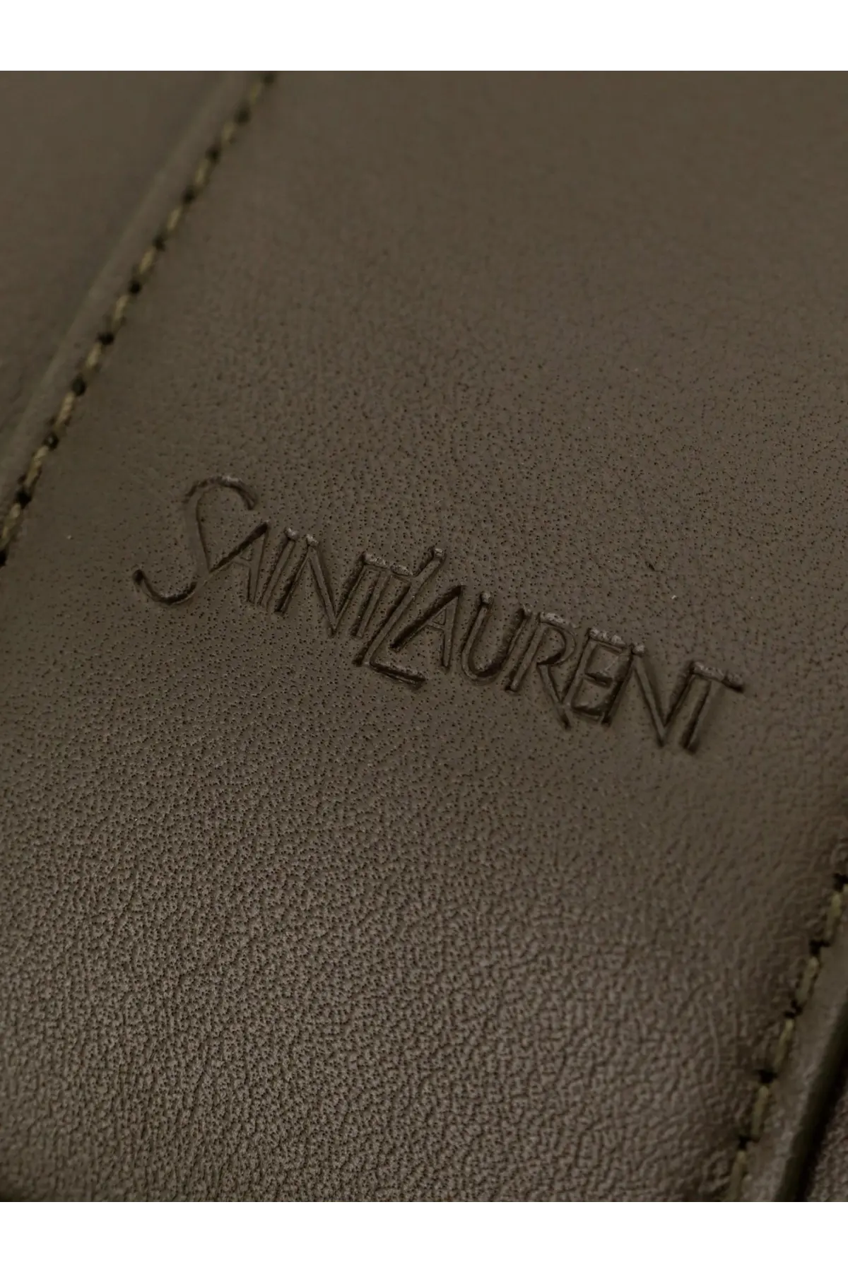 A taupe leather wallet with the saint laurent logo embossed paired with a green men’s oversize leather tote bag