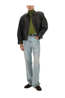 Black leather jacket with structured oversized fit and subtle stitching paired with saint laurent men’s wool silk green turtleneck