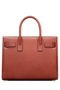A glossy terracotta-colored saint laurent sac de jour nano tote bag with structured design and top handles
