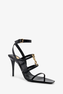 Saint Laurent women’s black patent leather strappy high heel sandal with gold-tone YSL logo clasp