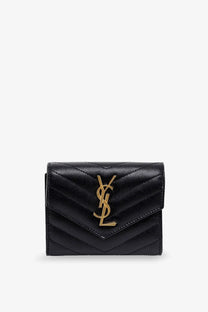 Saint Laurent women’s leather wallet in black featuring a quilted leather YSL card case with gold tone logo