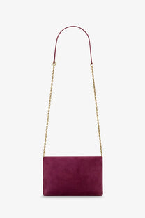 Saint Laurent women’s burgundy suede crossbody clutch with a gold-tone chain strap and suede material