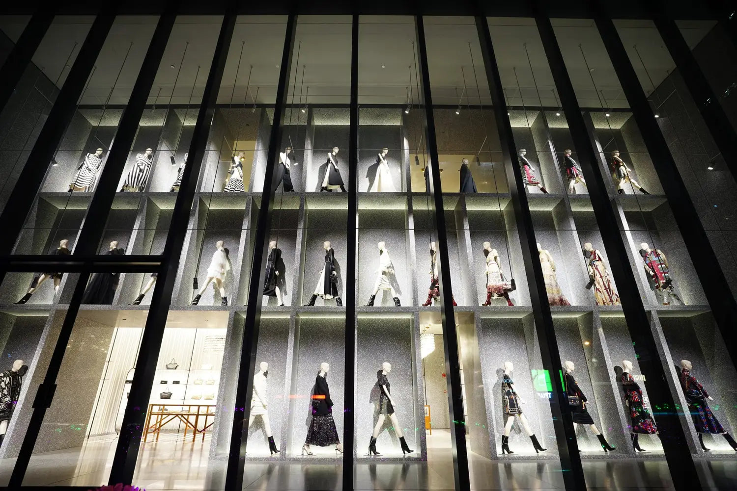 Multi-tiered fashion mannequins in sleek retail display, new luxury capital