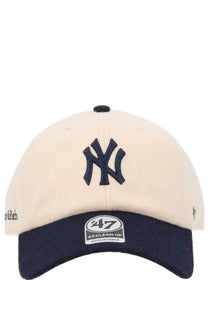 Cream-colored sporty &amp; rich unisex baseball hat with navy ny logo embroidered and navy brim featuring adjustable label