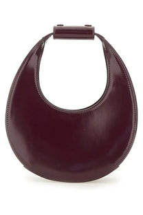 A sleek glossy burgundy leather Staud women’s mini moon bag with a minimalist crescent shape and top handle