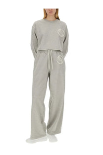 Gray cropped sweatshirt with white embroidered logo on chest and waistband paired with stella mccartney women’s jogging pants gray