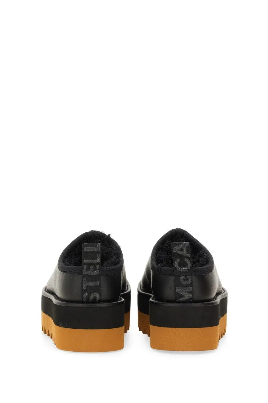 Back view of black leather stella mccartney women’s sneak elyse platform slip-ons with orange rubber sole