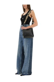 Black leather crossbody bag with bold repeating stella mccartney logo strap in white and black with wide leg blue jeans