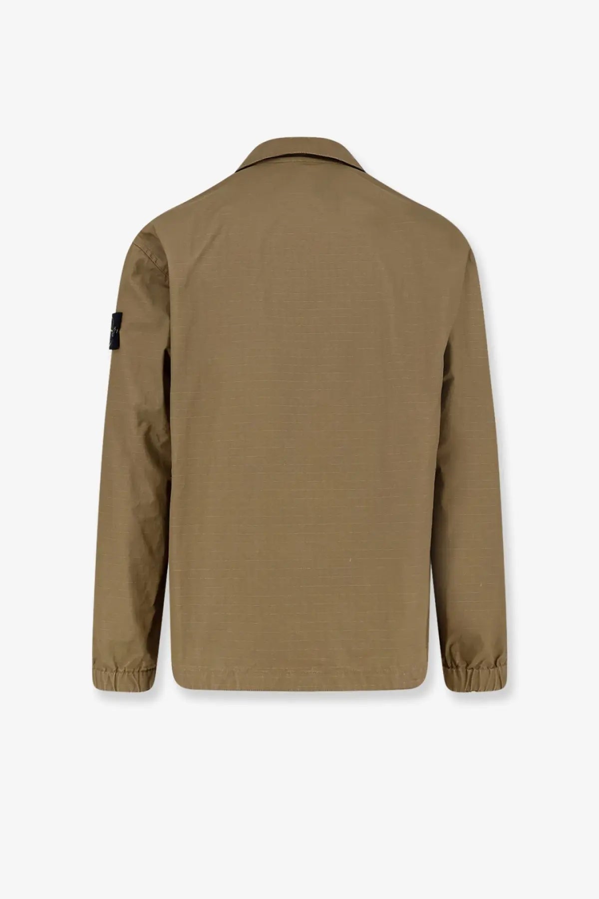 Tan utility jacket with subtle textured weave elasticated cuffs and black patch on left sleeve by stone island