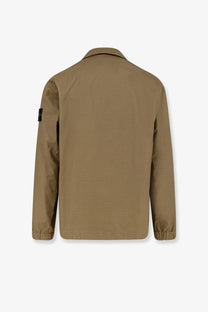 Tan utility jacket with subtle textured weave elasticated cuffs and black patch on left sleeve by stone island