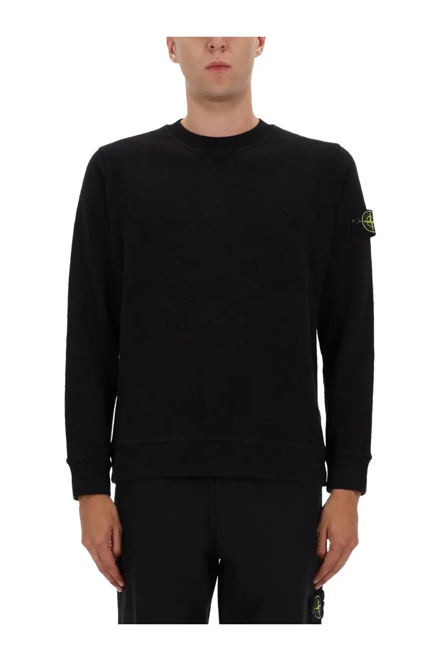 Stone Island men’s black cotton long-sleeved crewneck sweatshirt with small yellow logo patch on left sleeve