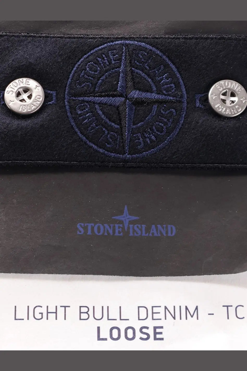 Dark blue stone island wallet in light bull denim with embroidered compass logo and silver button fastenings
