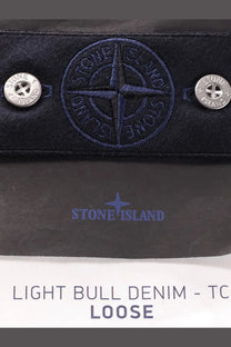 Dark blue stone island wallet in light bull denim with embroidered compass logo and silver button fastenings