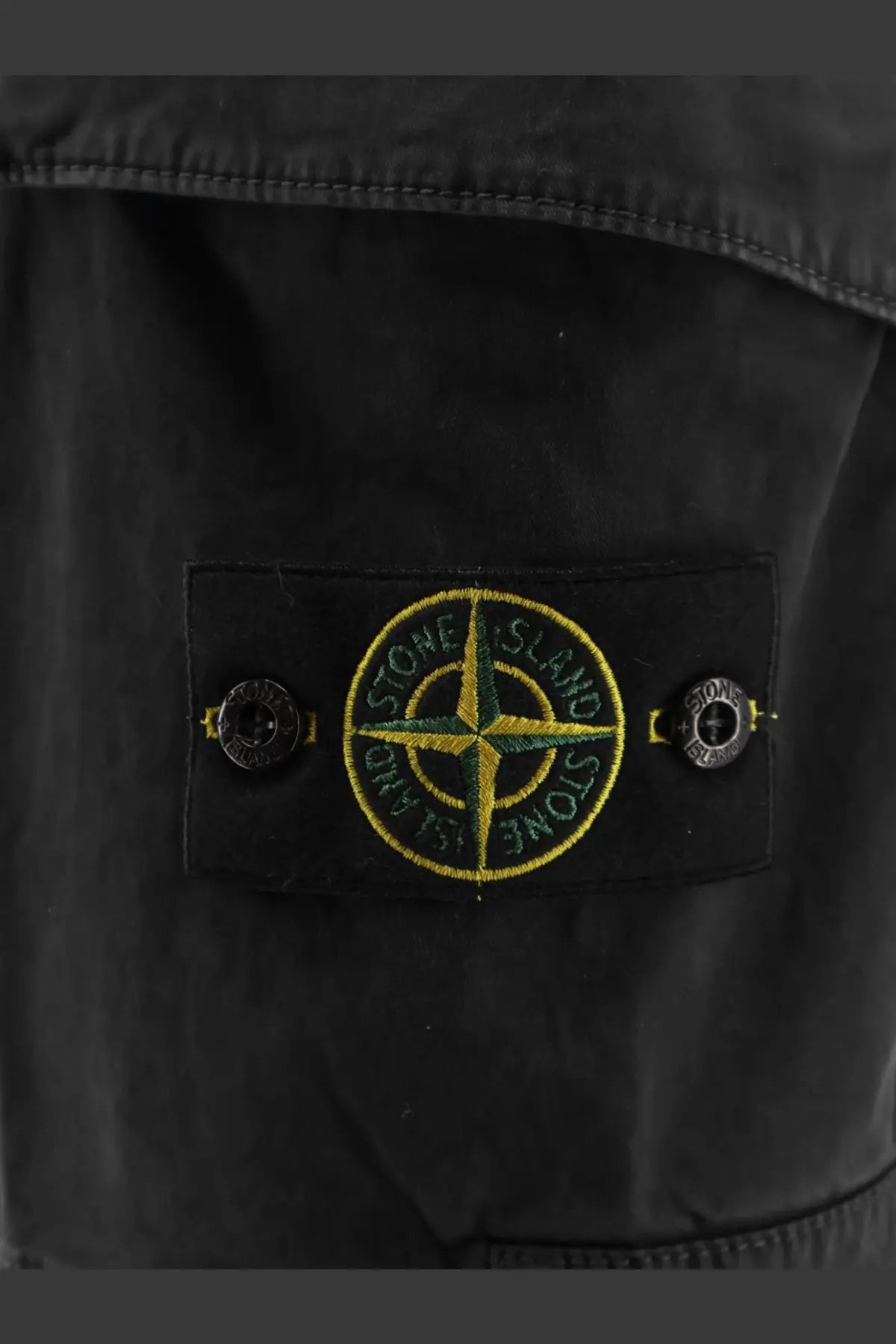Stone island men’s organic cotton black shorts featuring a black stone island jacket patch with yellow and green compass rose embroidery