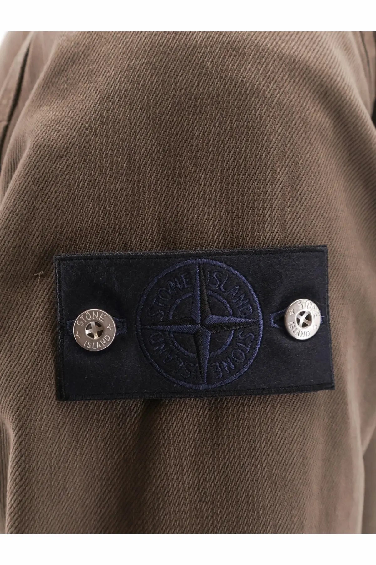 Stone island men’s overshirt cotton jacket umber with black embroidered stone island patch and silver-tone buttons on brown fabric