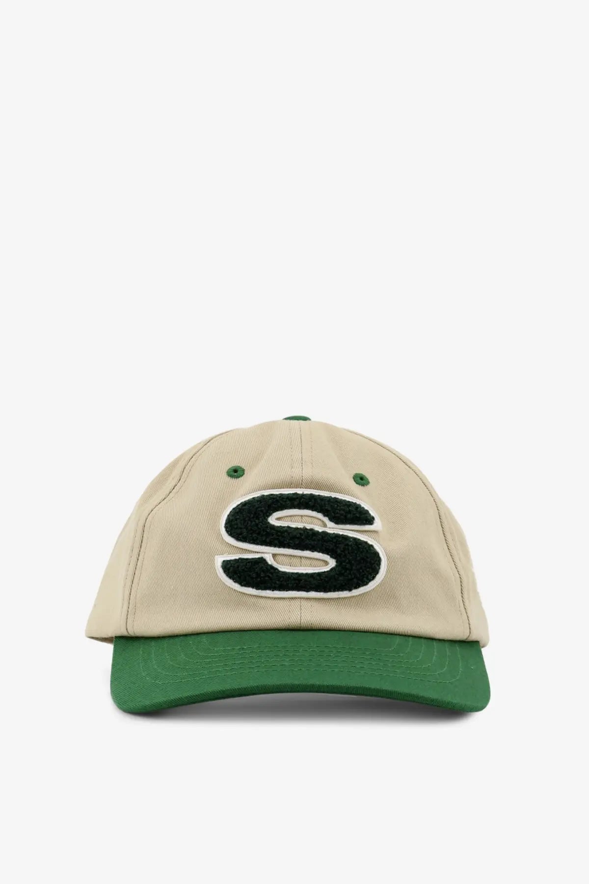 Beige stussy men’s cotton baseball cap with green brim and black embroidered s logo outlined in white