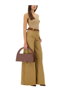 Thelatest women’s alma pants beige paired with a sleek minimalist brown leather handbag with a curved top handle