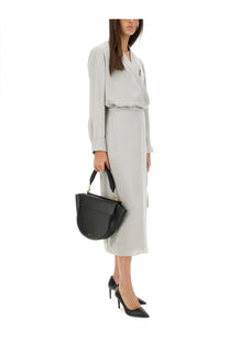 Black leather handbag with gold-tone hardware and structured curved silhouette paired with theory women’s grey silk shirt