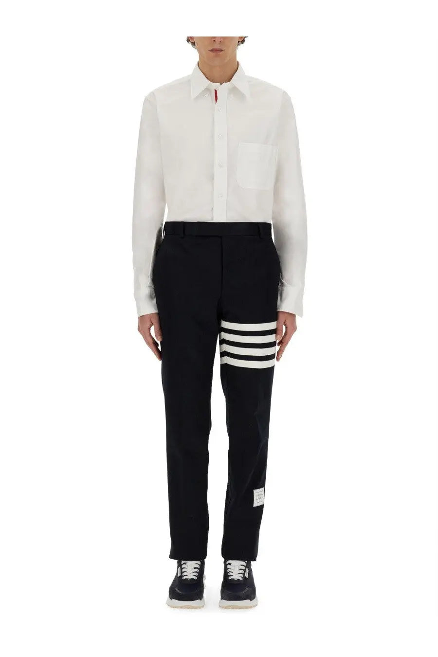 Black cotton Thom Browne trousers with three bold white stripes on the lower leg and a branded label at the hem