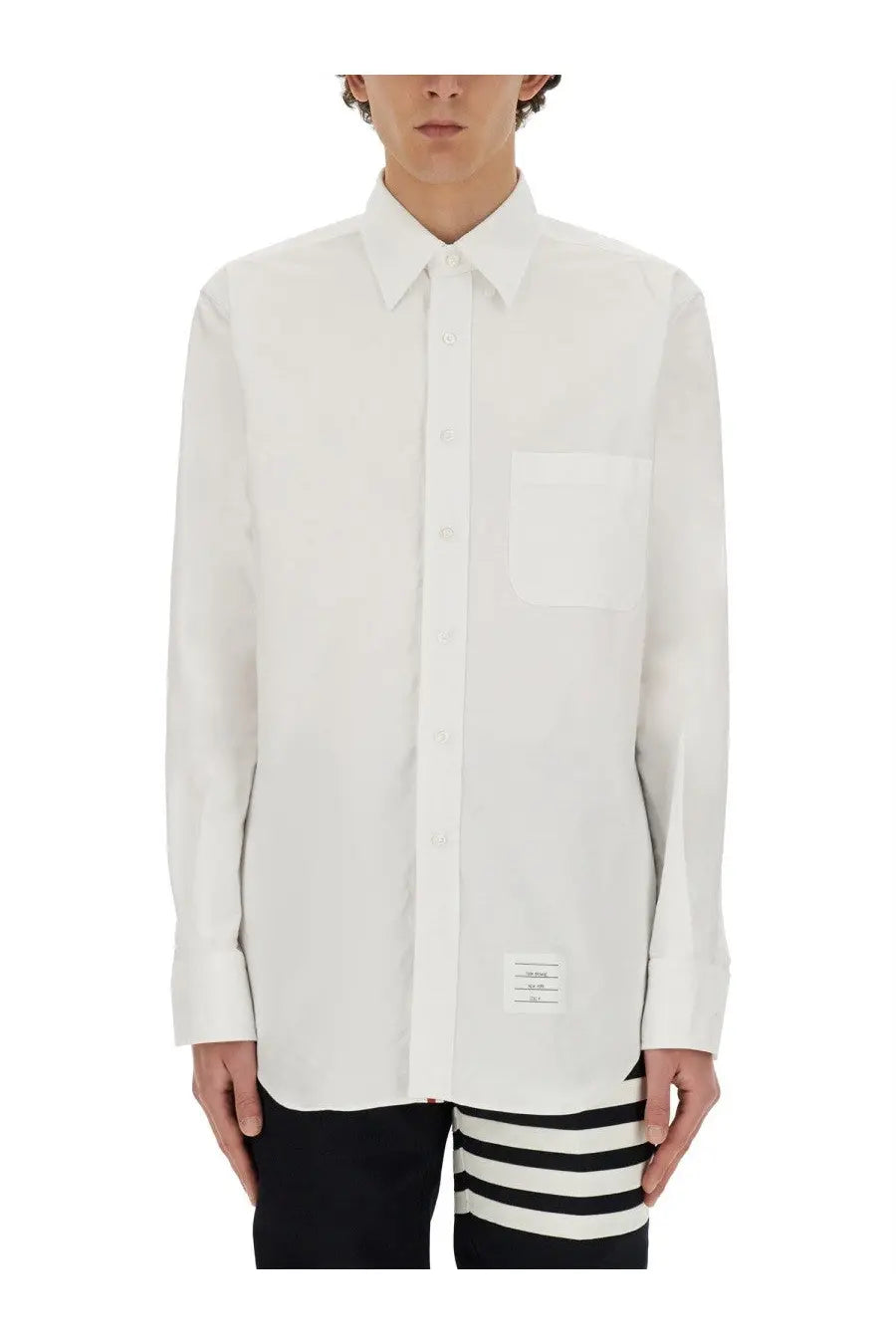 Thom Browne men’s white cotton long-sleeved button-up shirt with chest pocket and label at bottom hem