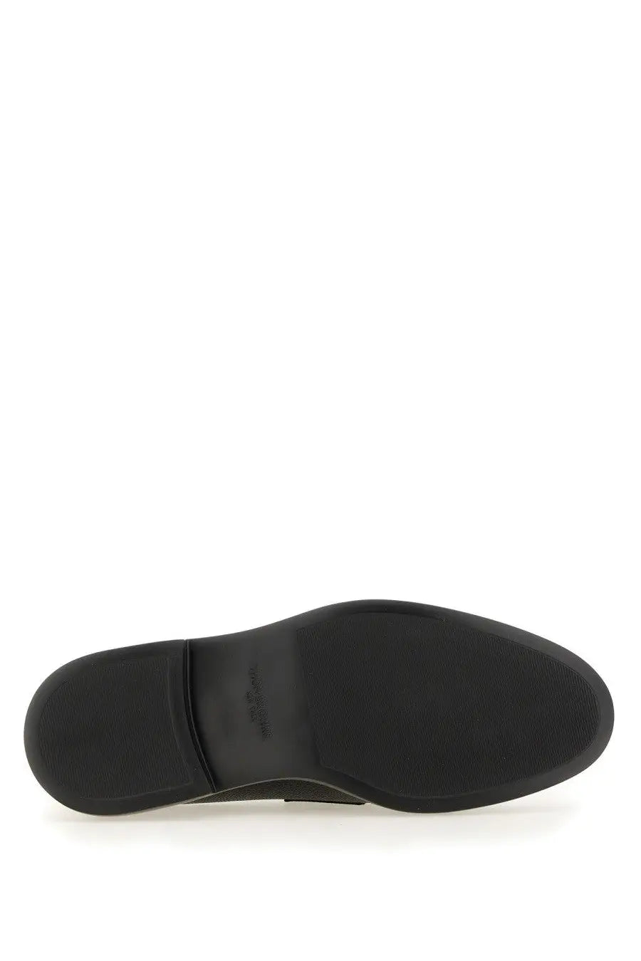 Black rubber sole of thom browne men’s moccasin penny black with textured grip pattern and embossed brand logo near heel