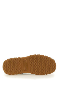 Tan rubber sole with textured wavy tread and embossed brand label on thom browne men’s trainer letterman blue