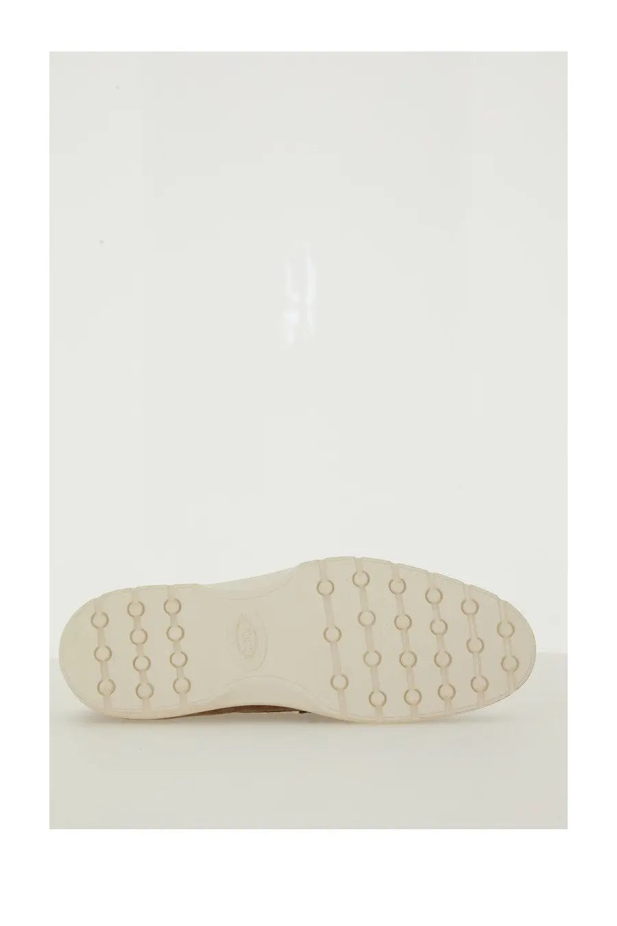 Tod’s men’s brown leather slipper loafer with cream-colored rubber sole and circular tread pattern visible near heel