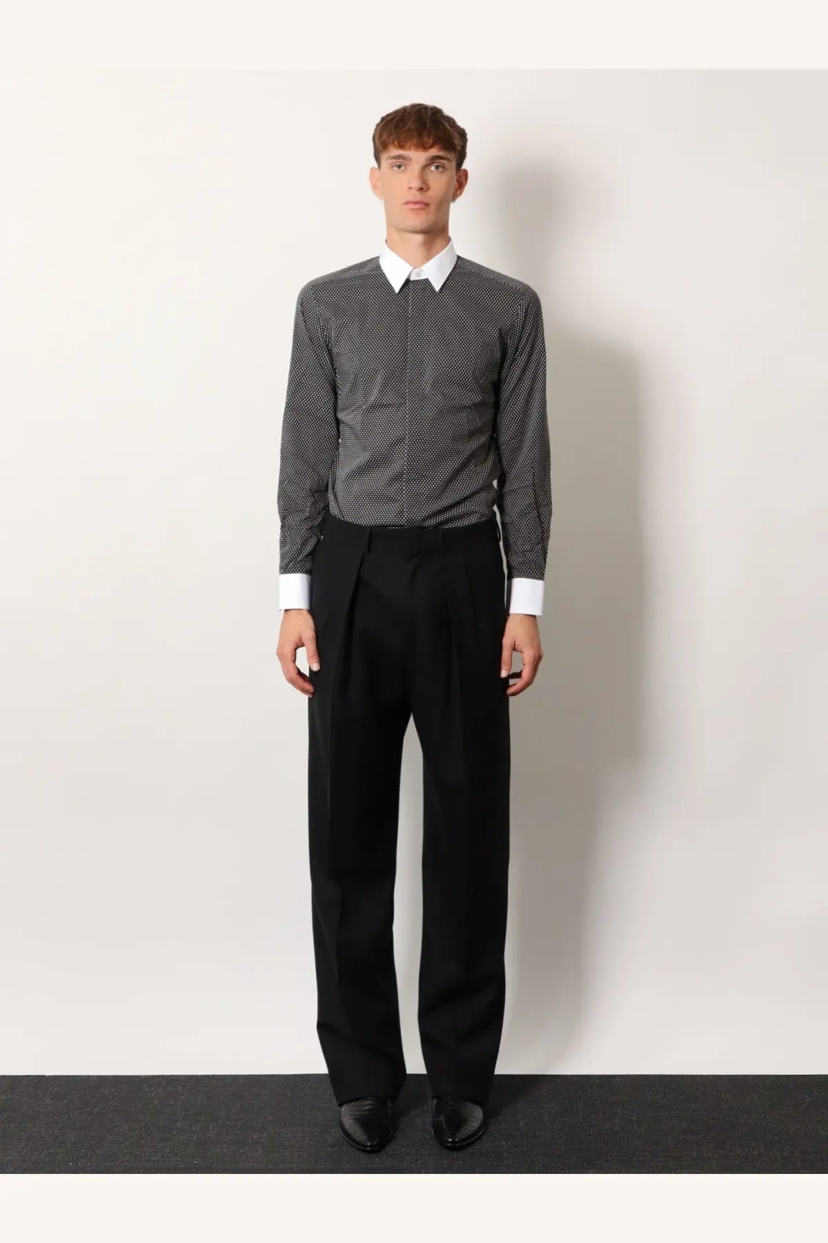Black pleated trousers with a sleek tailored fit paired with tom ford men’s microfantasy cotton shirt in black