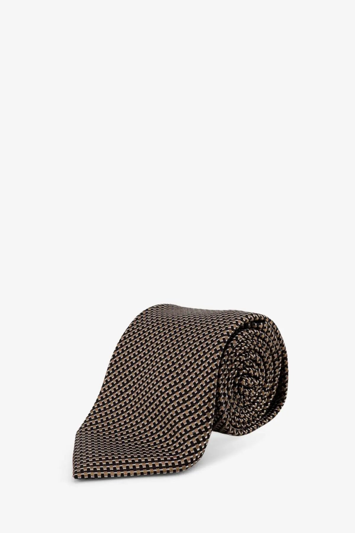 A neatly rolled tom ford men’s silk tie in beige with a subtle geometric pattern and smooth texture